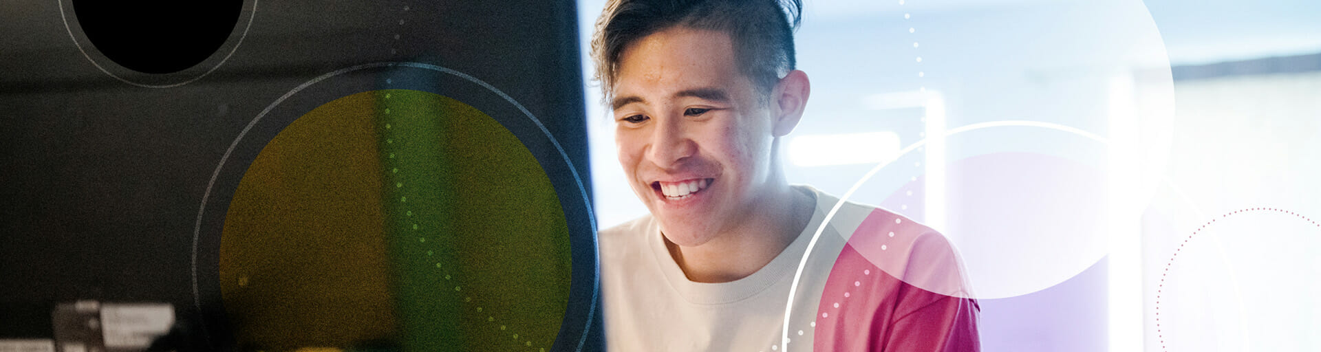 student looking at a computer and smiling