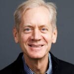Ryan Johnson smiling headshot with black coat