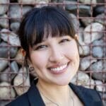 Bridget Rhee's headshot smiling with a rock fence background