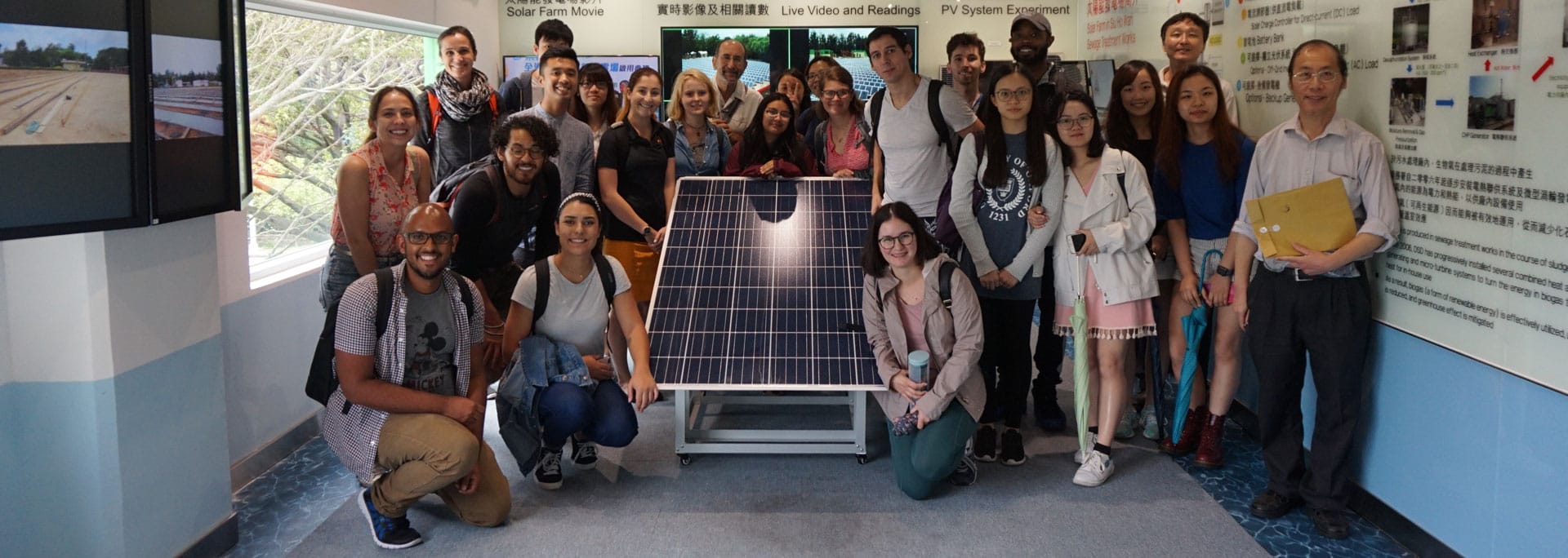 A group of people inside a building with a solar panel in the front